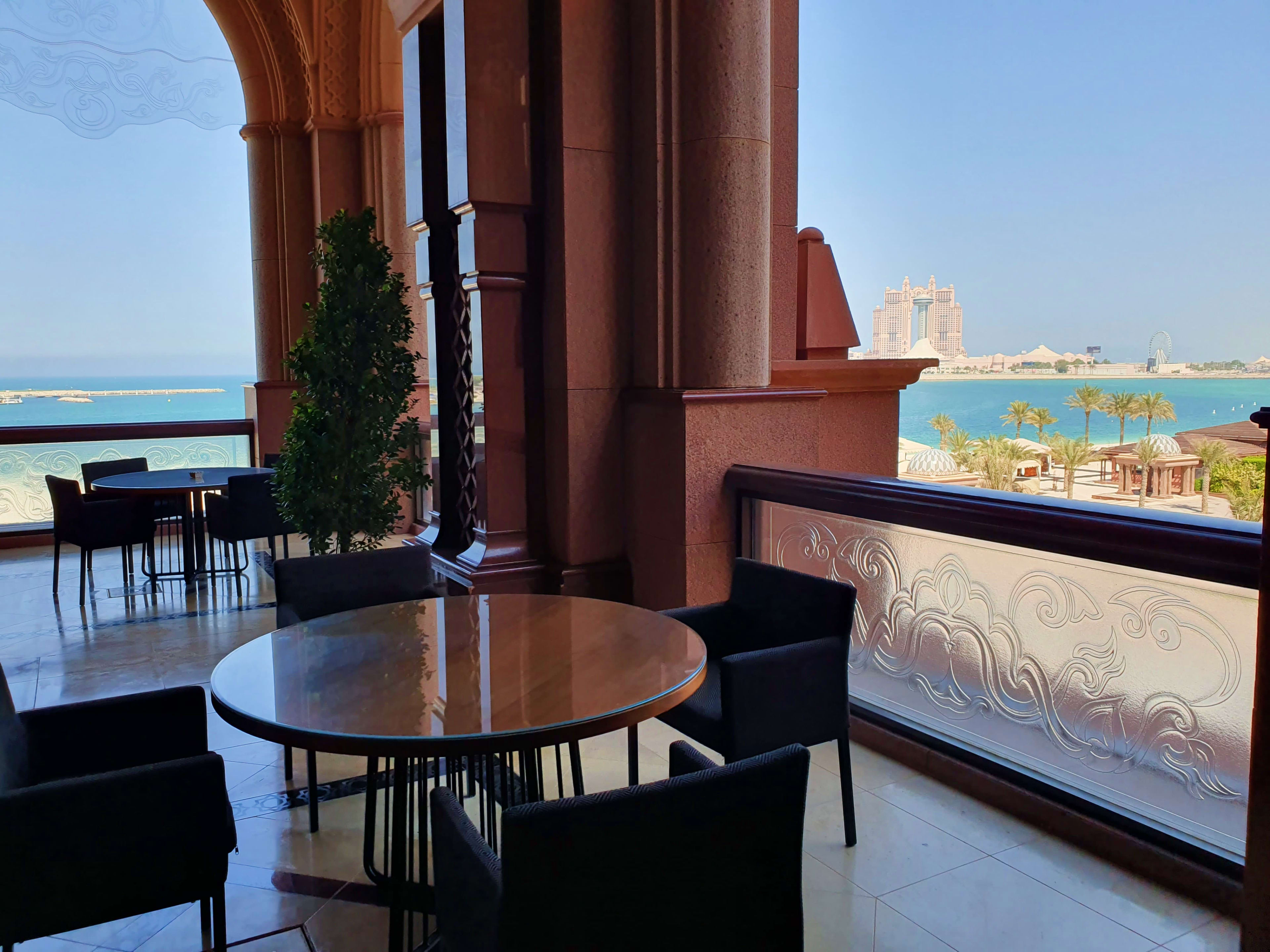 Luxury lounge at Emirates Palace Abu Dhabi with turquoise sea views, palm trees, and ornate architectural details